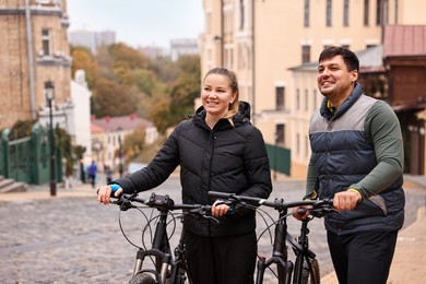 Photo of Beautiful happy couple with bicycles spending time together outdoors