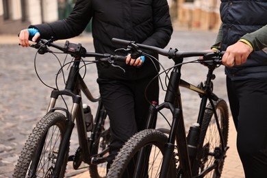 Beautiful happy couple with bicycles spending time together outdoors