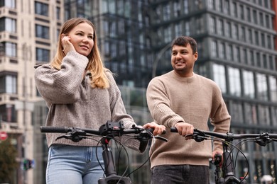 Photo of Beautiful happy couple with bicycles spending time together outdoors