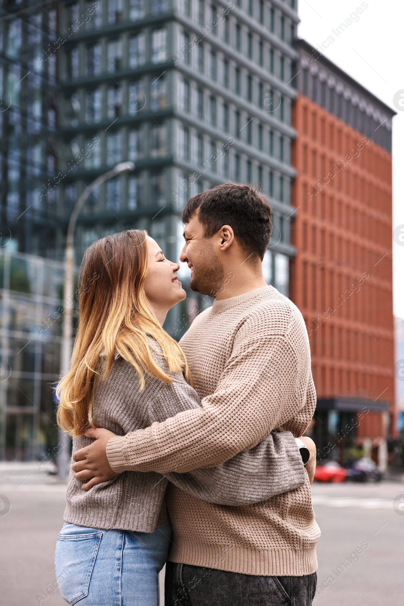 Photo of Beautiful happy couple kissing on city street