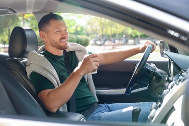 Photo of Man with cup of coffee driving modern car