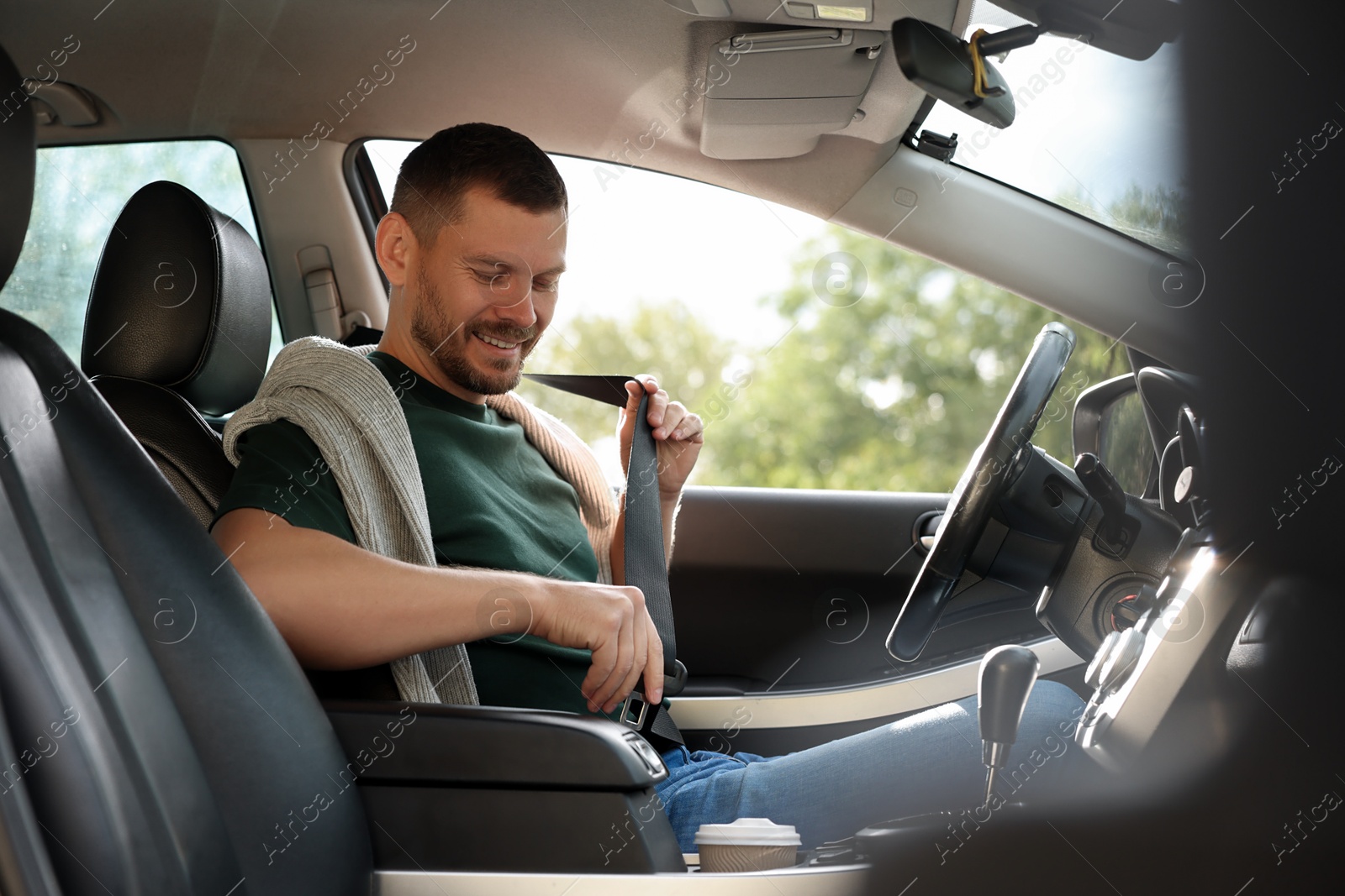 Photo of Man fastening seat belt in modern car