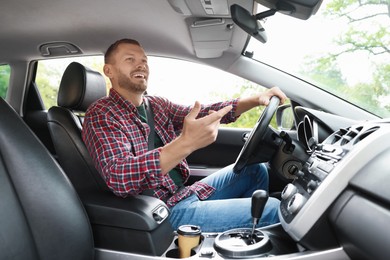 Photo of Man driving modern car, low angle view