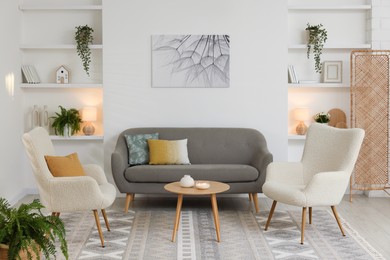 Beautiful armchairs, sofa and coffee table in living room. Interior design