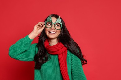 Photo of Beautiful woman with party glasses on red background. Christmas celebration