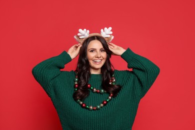 Photo of Beautiful woman with Christmas accessories on red background