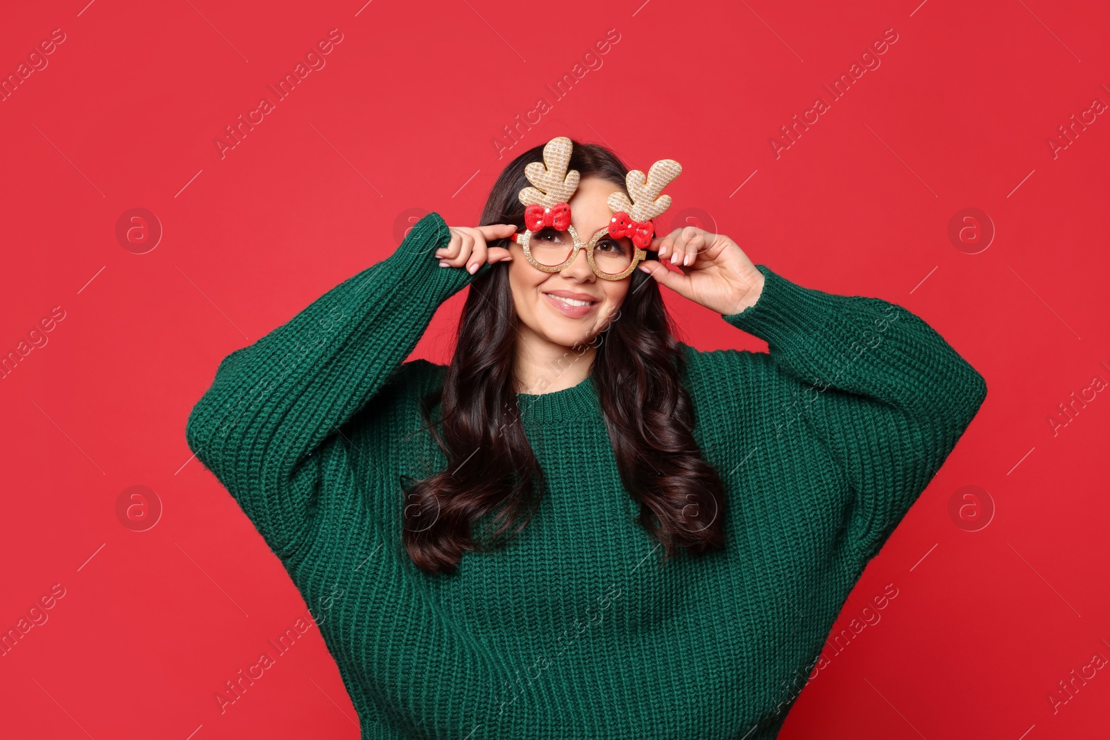 Photo of Happy woman with party glasses on red background. Christmas celebration