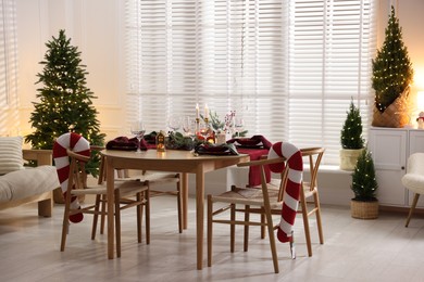 Photo of Christmas table setting with stylish dishware and festive decor indoors