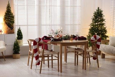 Photo of Christmas table setting with stylish dishware and festive decor indoors