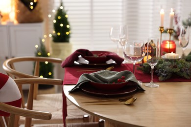 Photo of Christmas table setting with stylish dishware and festive decor indoors