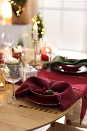 Photo of Christmas table setting with stylish dishware and festive decor indoors