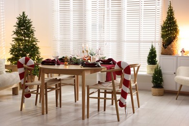 Photo of Christmas table setting with stylish dishware and festive decor indoors