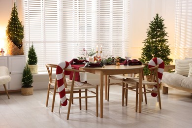 Photo of Christmas table setting with stylish dishware and festive decor indoors