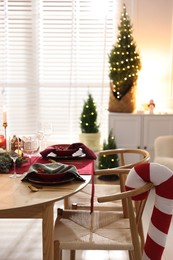 Photo of Christmas table setting with stylish dishware and festive decor indoors