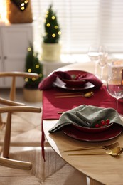 Photo of Christmas table setting with stylish dishware and festive decor indoors