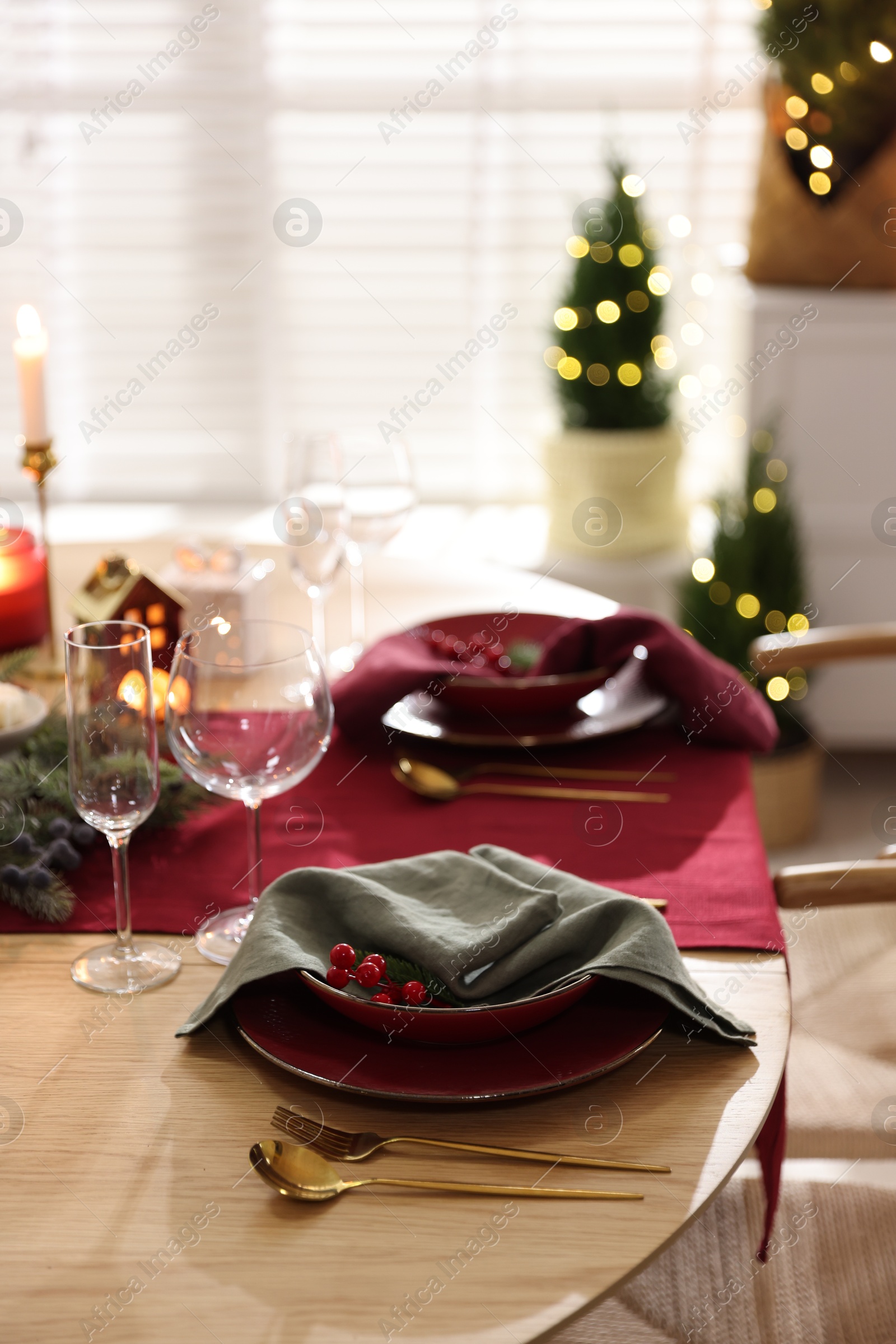 Photo of Christmas table setting with stylish dishware and festive decor indoors