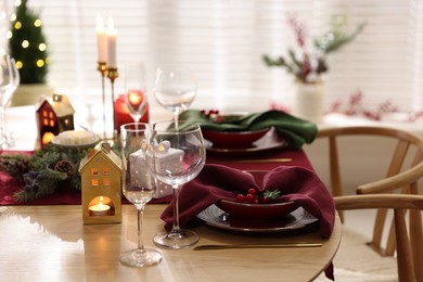 Photo of Christmas table setting with stylish dishware and festive decor indoors