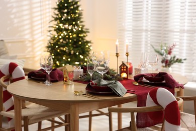 Photo of Christmas table setting with stylish dishware and festive decor indoors