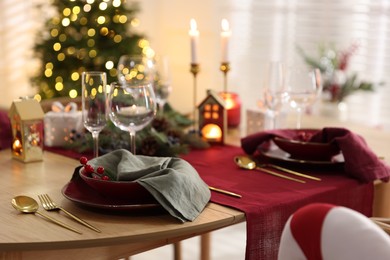 Photo of Christmas table setting with stylish dishware and festive decor indoors