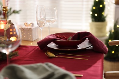 Photo of Christmas table setting with stylish dishware and festive decor indoors