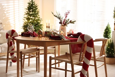 Photo of Christmas table setting with stylish dishware and festive decor indoors