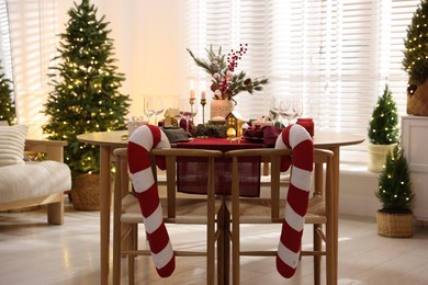 Photo of Christmas table setting with stylish dishware and festive decor indoors