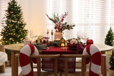 Photo of Christmas table setting with stylish dishware and festive decor indoors