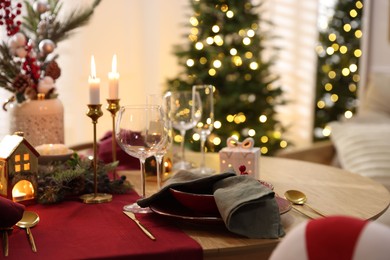 Photo of Christmas table setting with stylish dishware and festive decor indoors