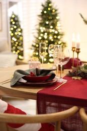 Photo of Christmas table setting with stylish dishware and festive decor indoors