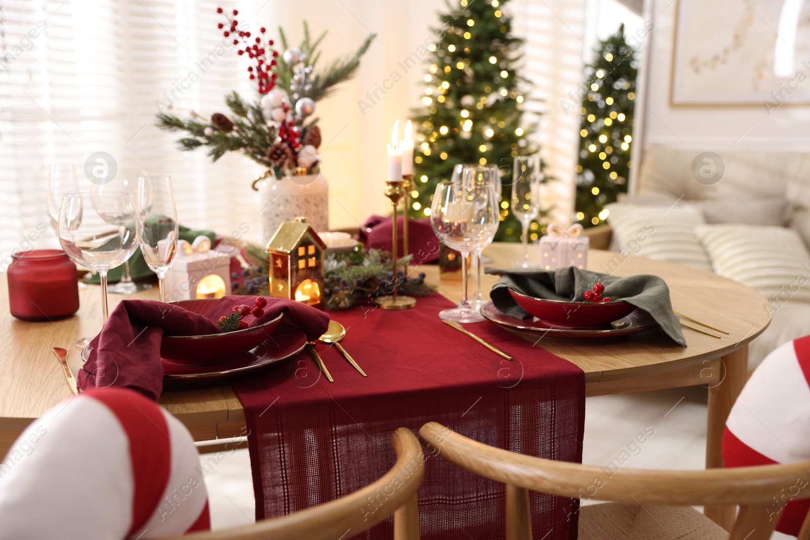 Photo of Christmas table setting with stylish dishware and festive decor indoors