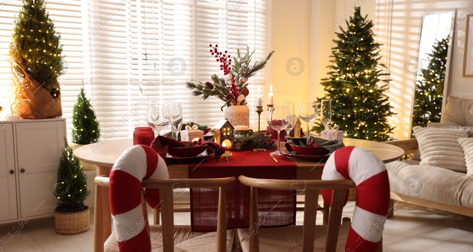 Photo of Christmas table setting with stylish dishware and festive decor indoors