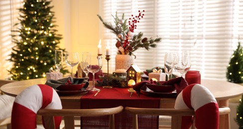 Photo of Christmas table setting with stylish dishware and festive decor indoors