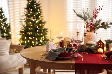 Photo of Christmas table setting with stylish dishware and festive decor indoors