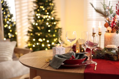 Photo of Christmas table setting with stylish dishware and festive decor indoors