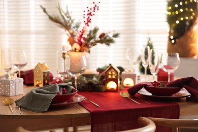 Photo of Christmas table setting with stylish dishware and festive decor indoors