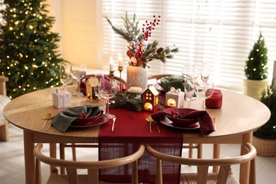 Photo of Christmas table setting with stylish dishware and festive decor indoors