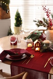 Photo of Christmas table setting with stylish dishware and festive decor indoors