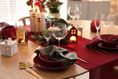 Photo of Christmas table setting with stylish dishware and festive decor indoors