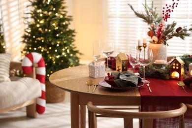 Photo of Christmas table setting with stylish dishware and festive decor indoors