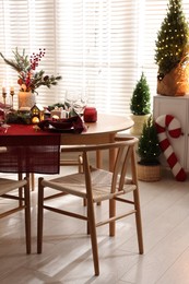 Photo of Christmas table setting with stylish dishware and festive decor indoors