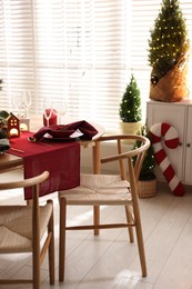 Photo of Christmas table setting with stylish dishware and festive decor indoors