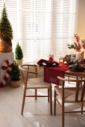 Photo of Christmas table setting with stylish dishware and festive decor indoors