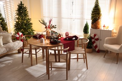 Photo of Christmas table setting with stylish dishware and festive decor indoors