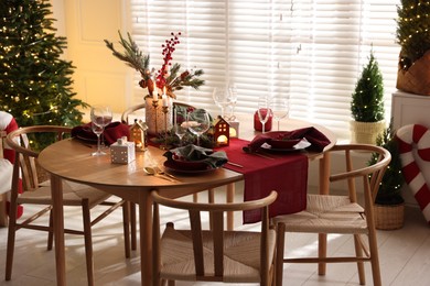 Photo of Christmas table setting with stylish dishware and festive decor indoors