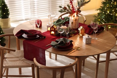 Photo of Christmas table setting with stylish dishware and festive decor indoors