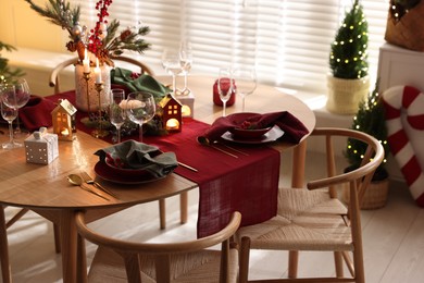 Photo of Christmas table setting with stylish dishware and festive decor indoors