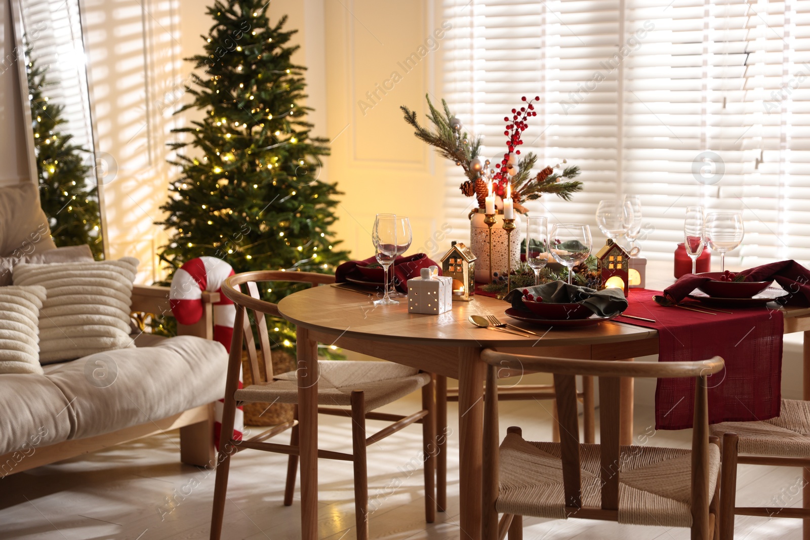 Photo of Christmas table setting with stylish dishware and festive decor indoors