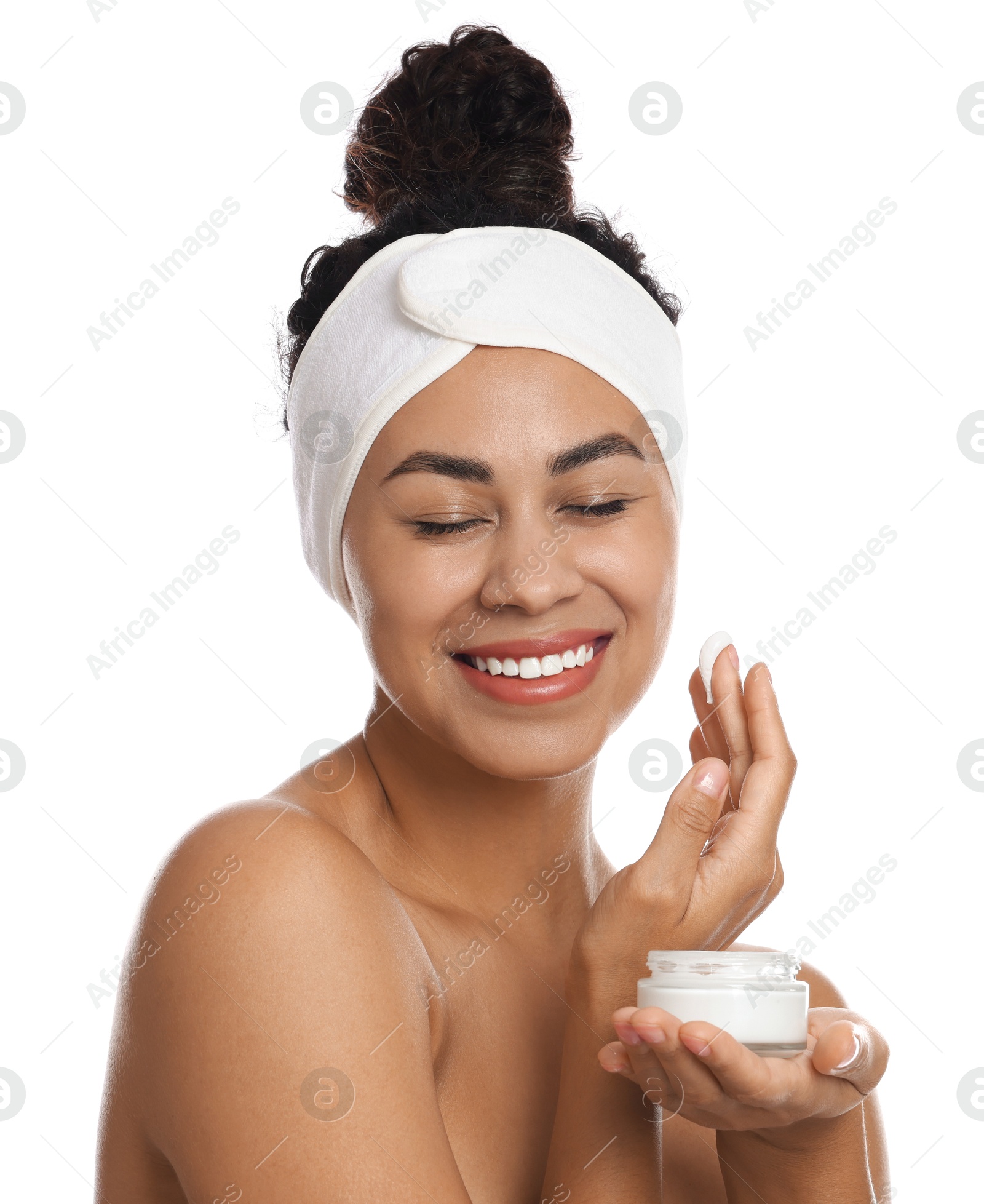 Photo of Beautiful woman applying cream onto face against white background