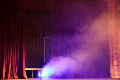 Photo of Professional spotlight and smoke on stage in theatre