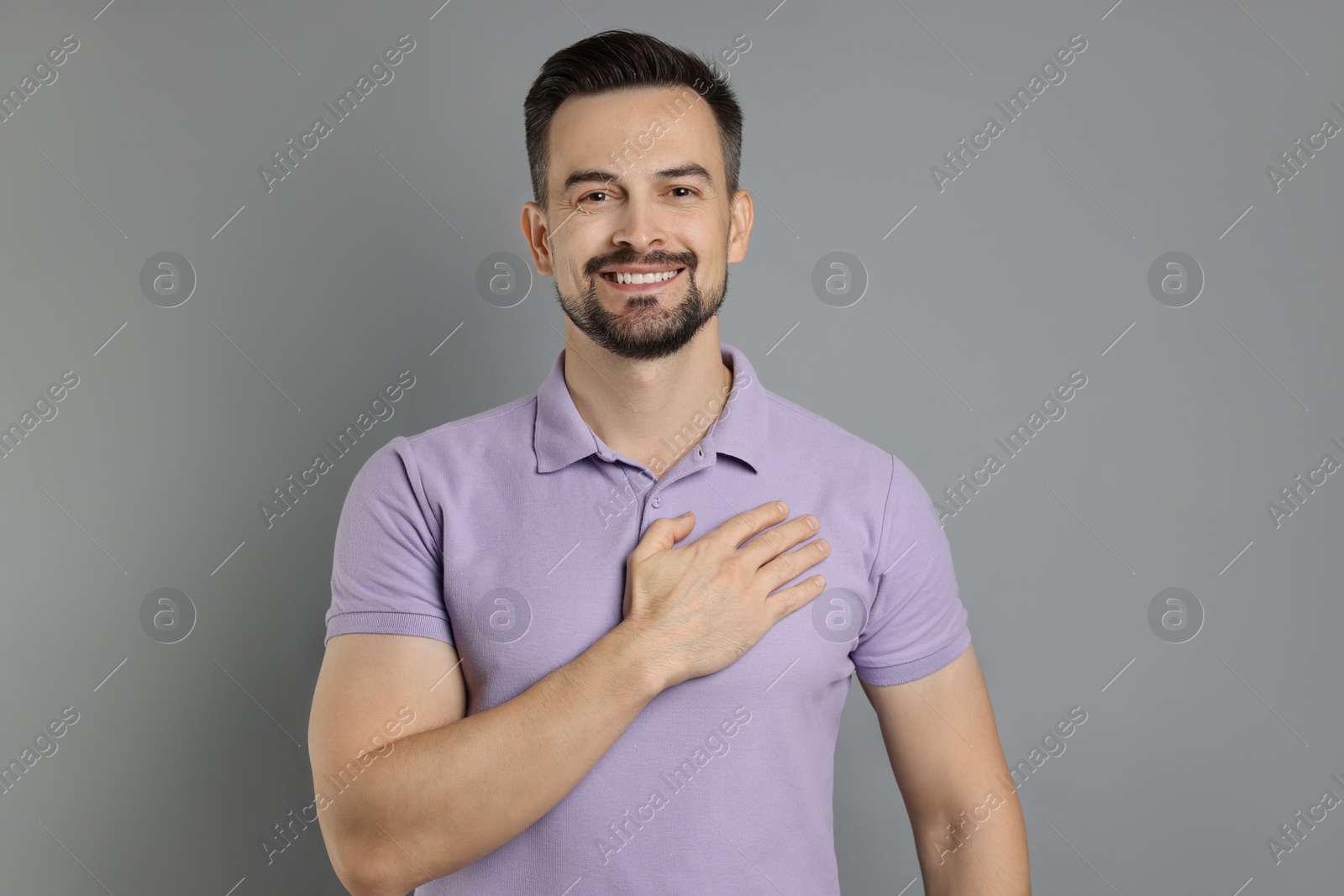 Photo of Man making promise on grey background. Oath gesture